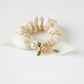 Gifty floral hair tie placed next to matching floral accessories on a wooden surface