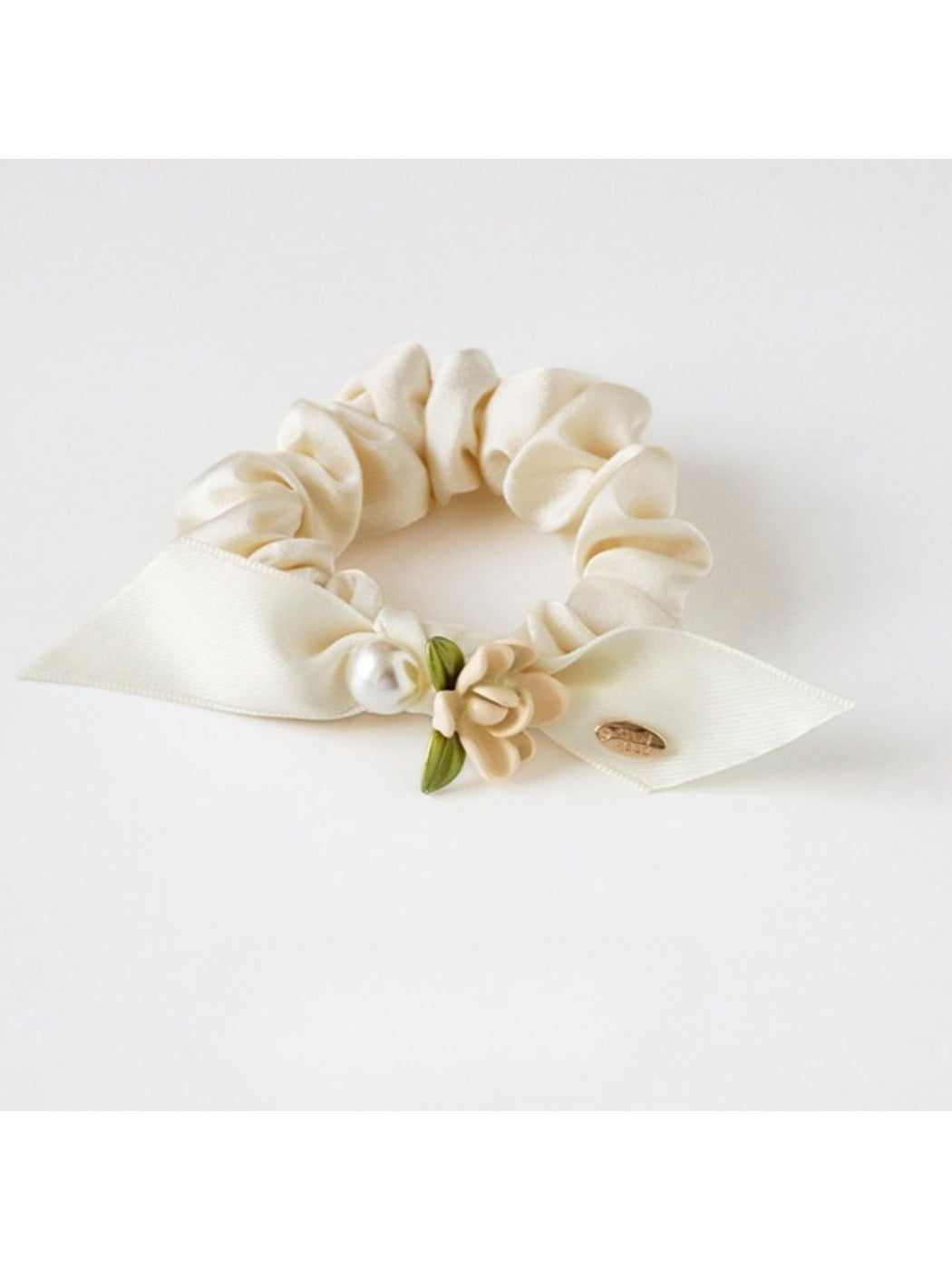 Gifty floral hair tie placed next to matching floral accessories on a wooden surface