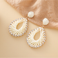 Earedge Bohemian raffia earrings displayed on a wooden surface