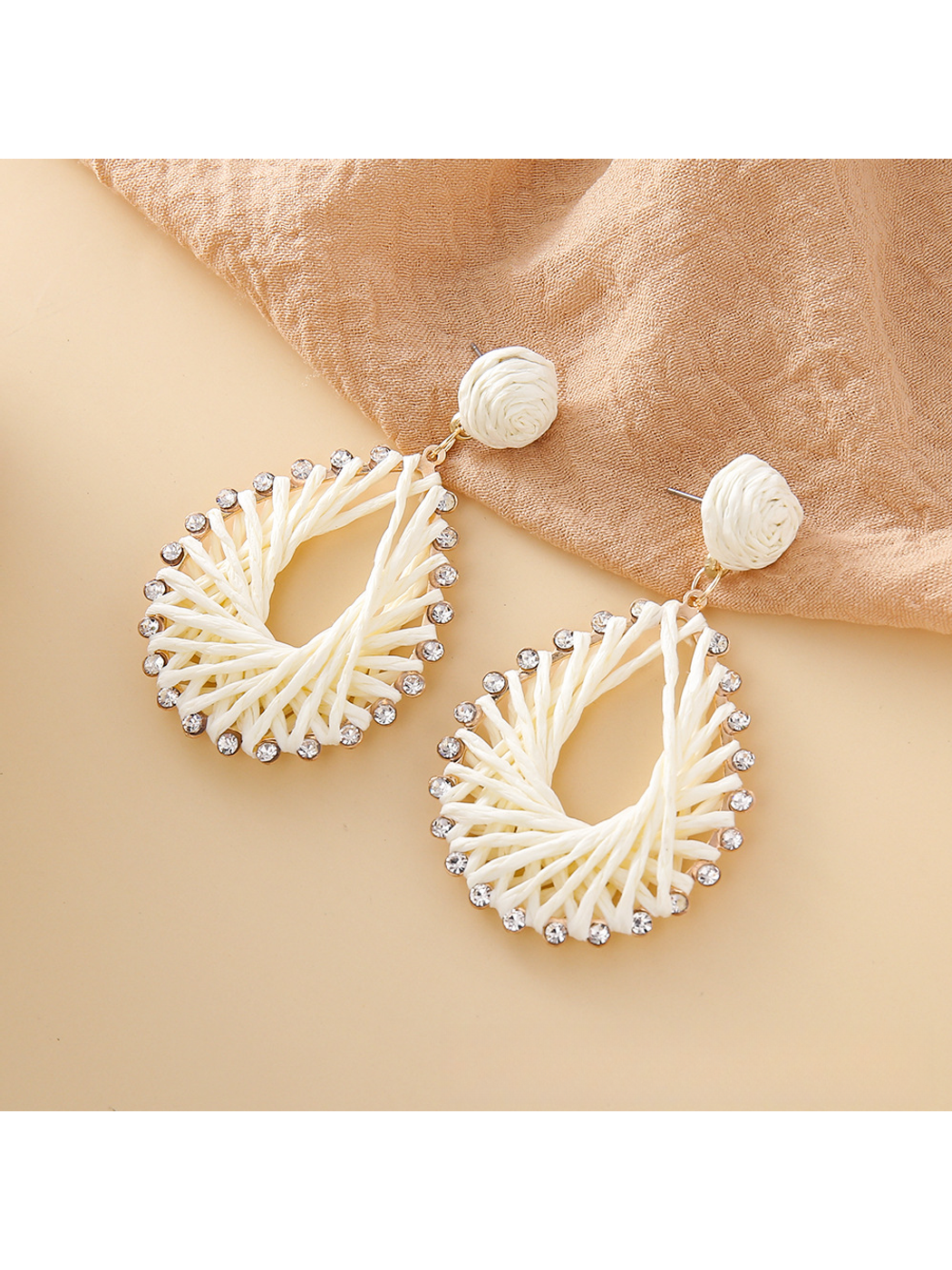 Earedge Bohemian raffia earrings displayed on a wooden surface
