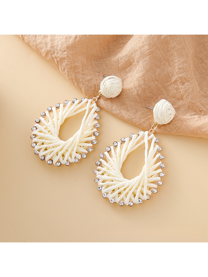 Earedge Bohemian raffia earrings displayed on a wooden surface