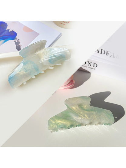Beau hair claw clip displayed on a white background highlighting its curved shape