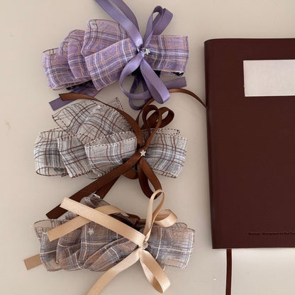 Close-up of Beau checkered bow hair clip with black and white pattern on a white background