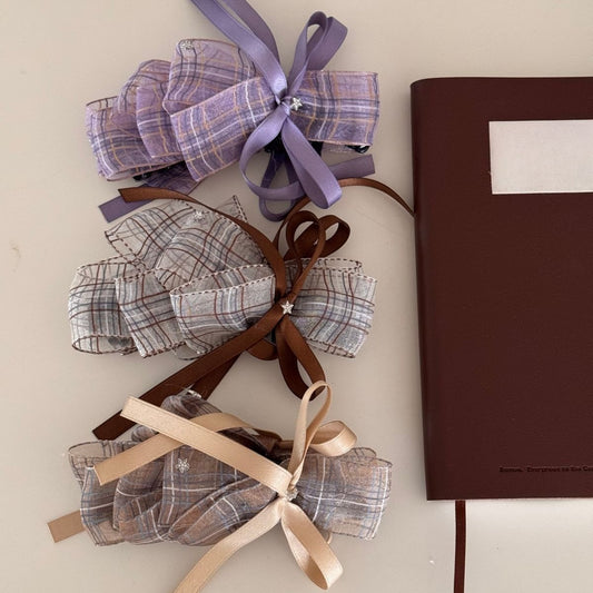 Close-up of Beau checkered bow hair clip with black and white pattern on a white background