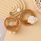 Pair of vintage rattan woven circle earrings displayed on white background