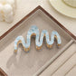 Beau hair clip photographed from an angle emphasizing wave details