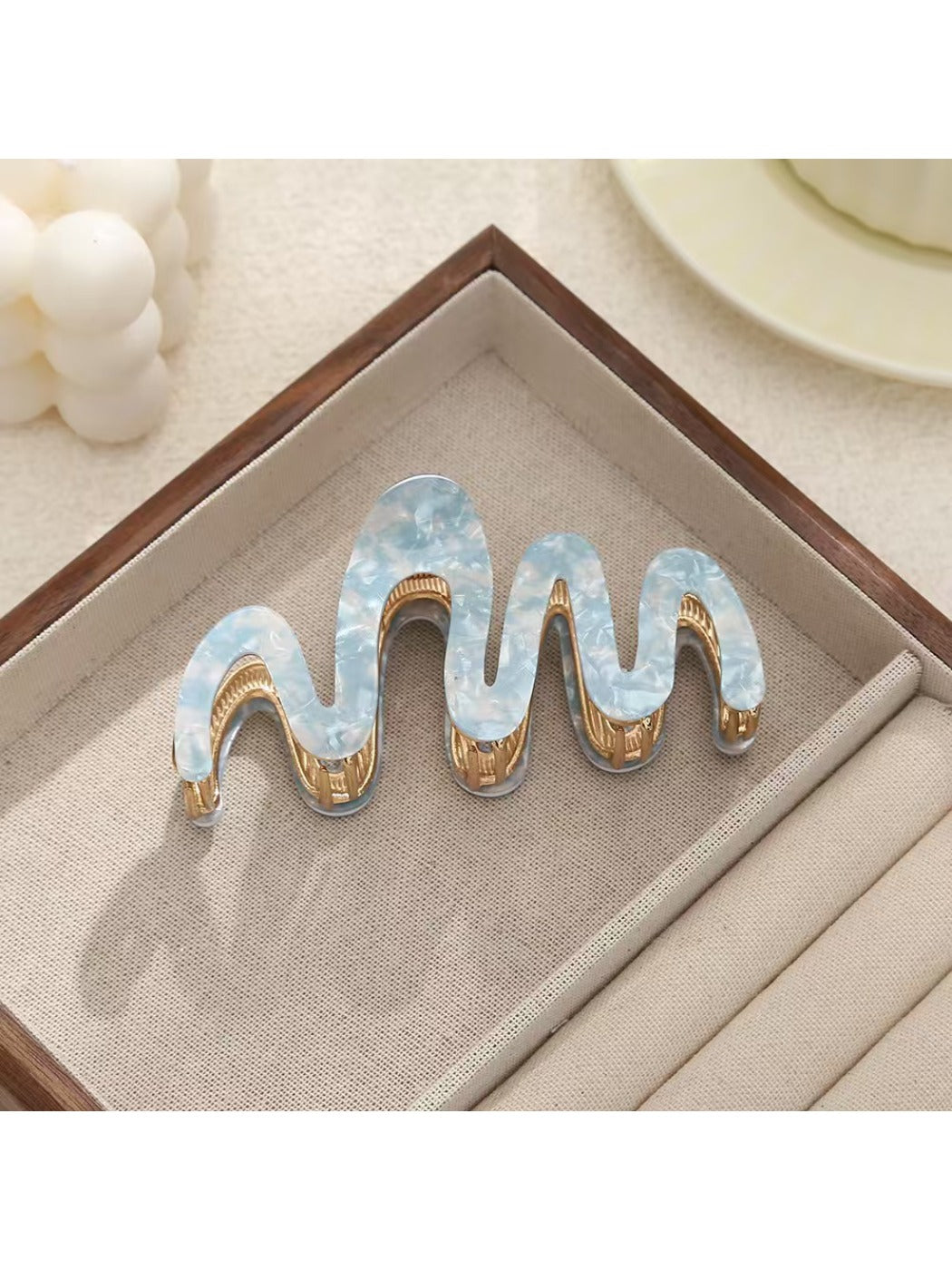 Beau hair clip photographed from an angle emphasizing wave details