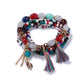 Detailed shot of Lovra bracelet tassel pendant with gold-tone finish and beads