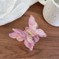 Butterfly claw clip in pastel pink with metal spring mechanism visible