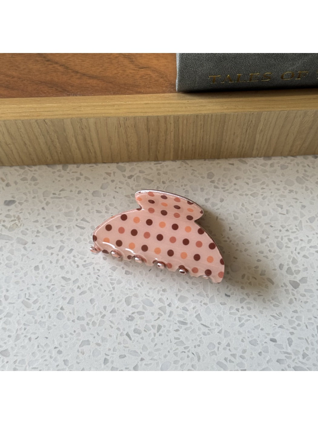 Beau polka dot claw clip resting on a wooden surface