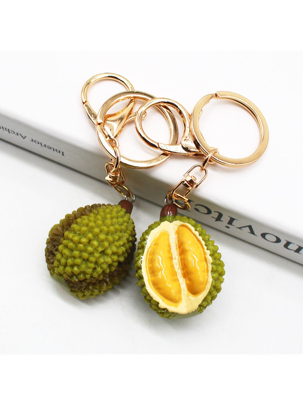 Durian shaped keychain attached to a silver keyring on a white background