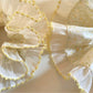 Side view of yellow pleated scrunchie showing texture and print