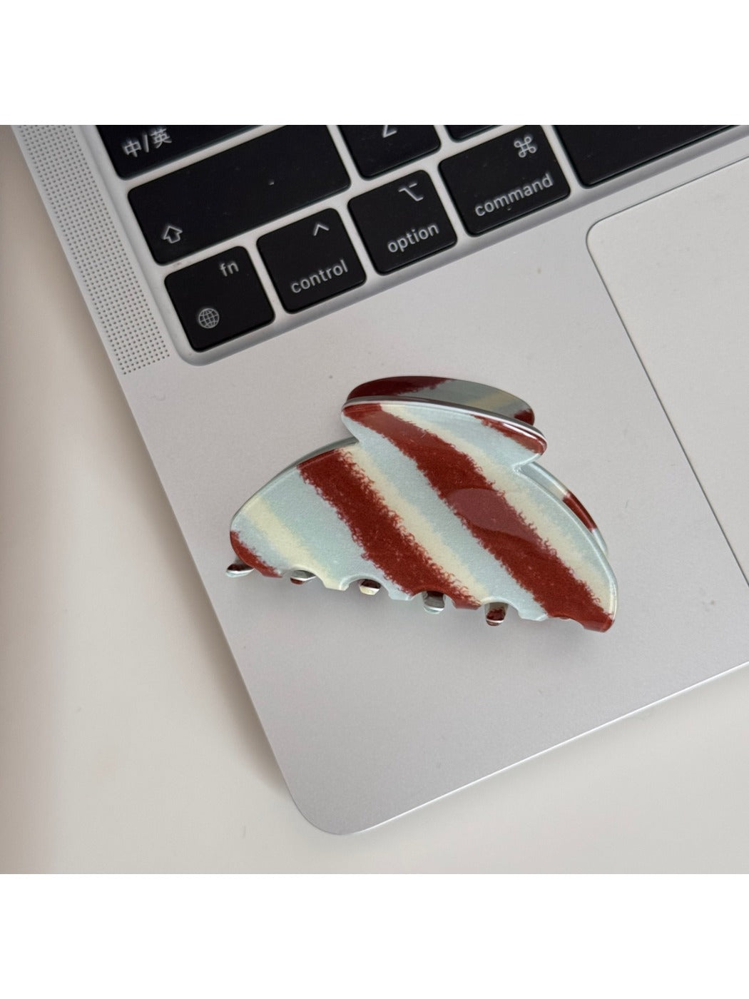 Beau Retro Twill Acetate Clip displayed on a wooden surface with natural light