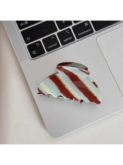 Beau Retro Twill Acetate Clip displayed on a wooden surface with natural light