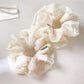 Close-up of white tulle ruffle scrunchie with layered fabric texture