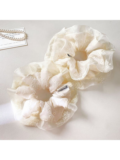 Close-up of white tulle ruffle scrunchie with layered fabric texture