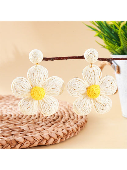 Pair of earedge knitted flower earrings displayed on a white background