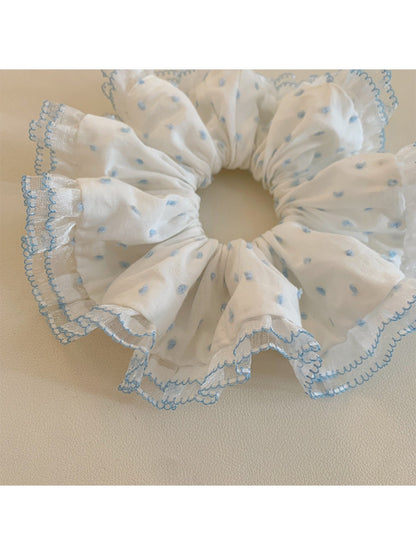 Polka dot scrunchie styled on a wrist as a fashion accessory