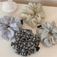 Gifty daisy print scrunchie displayed on a white background showing full circular shape