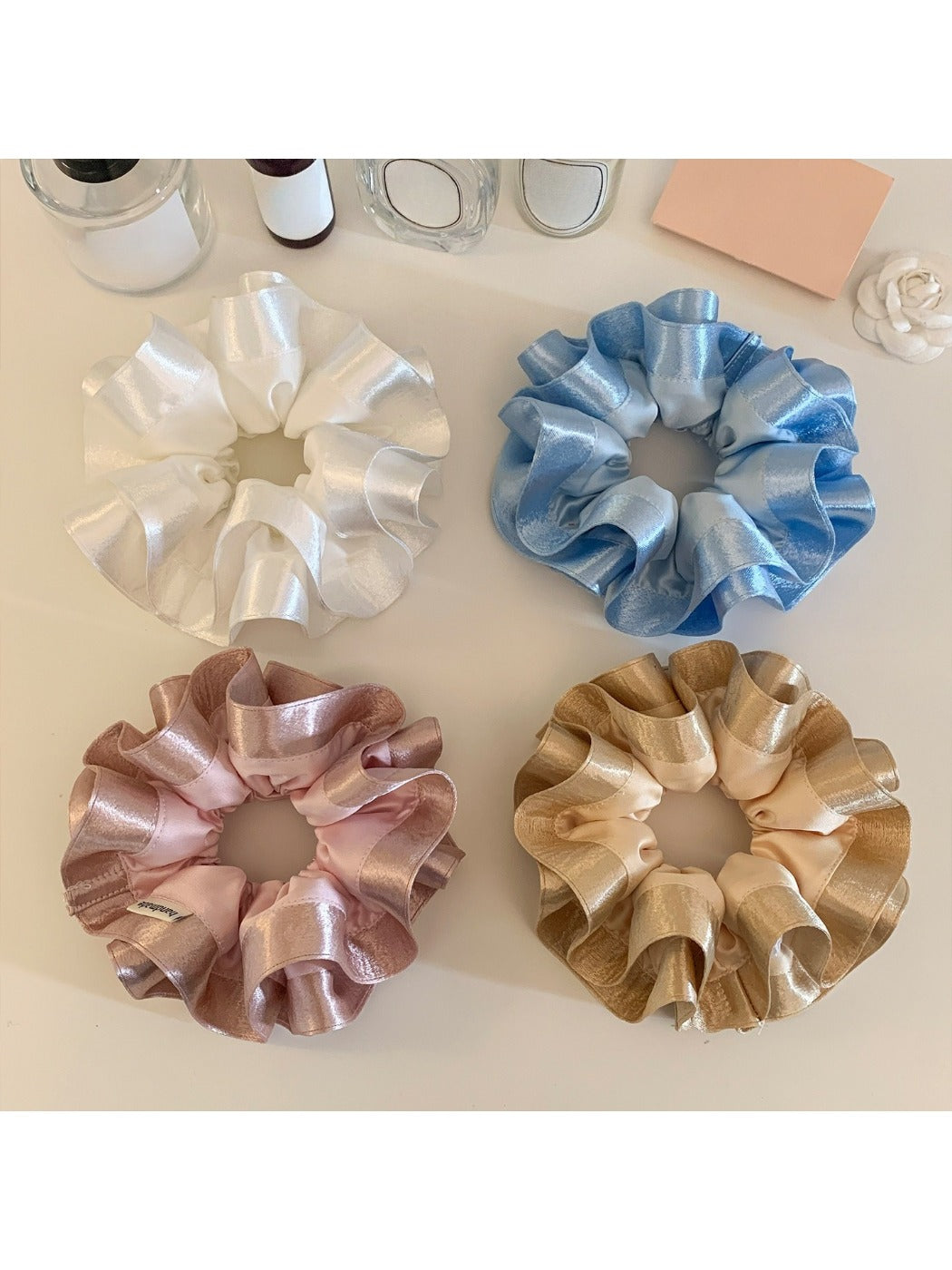 Gifty satin ruffle scrunchie displayed on a wooden surface showing texture and shine