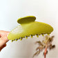 Beau polka dot acetate claw clip resting on a wooden surface