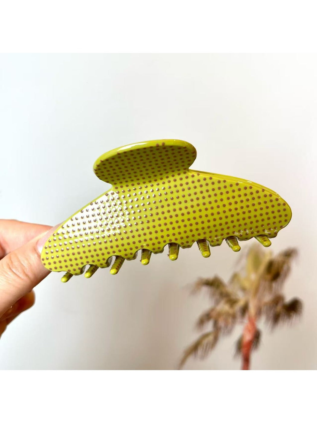 Beau polka dot acetate claw clip resting on a wooden surface
