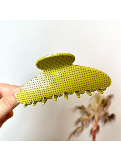 Beau polka dot acetate claw clip resting on a wooden surface