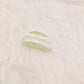 Beau claw clip in marble pattern held in hand to show size and detail