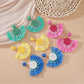 Close-up of Earedge minimalist fan shaped drop earrings on white background