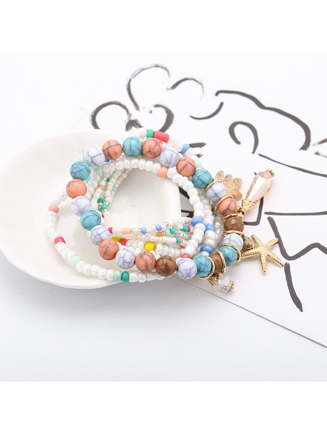 Lovra stackable bracelet worn on wrist with ocean-inspired charms and beads
