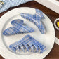 Side view of blue plaid shark hair claw clip showing curved teeth