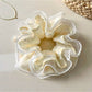 Close-up of Gifty chic printed ruffled scrunchie with floral pattern on fabric