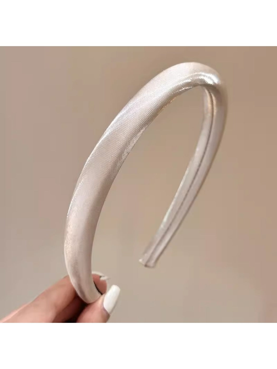 Close-up of smooth bright satin headband showing shiny texture and stitching