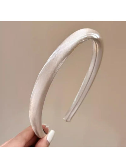 Close-up of smooth bright satin headband showing shiny texture and stitching