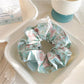 Side view of the blue ruffled scrunchie showing fabric texture