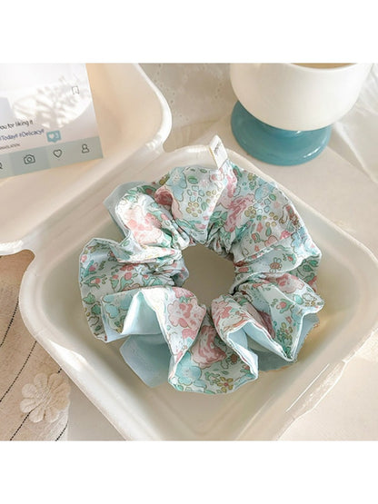 Side view of the blue ruffled scrunchie showing fabric texture