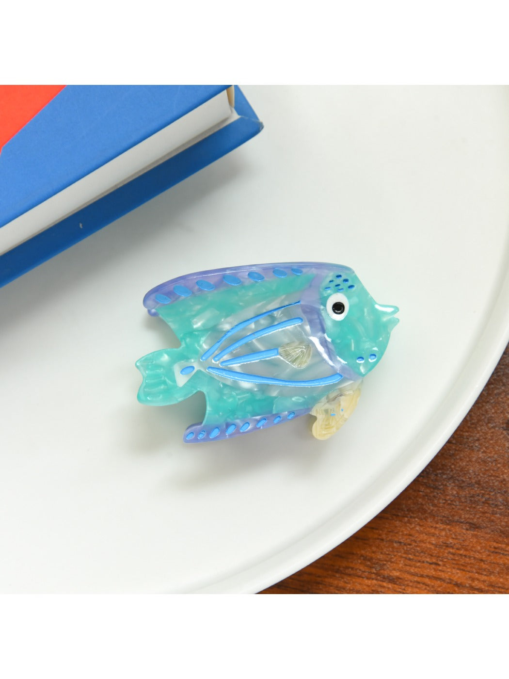 Beau tropical fish hair clip photographed with natural light emphasizing translucent material