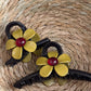 Close-up of beige flower-shaped claw clip showing petal details