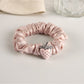 Strawberry hair tie styled with casual outfit on a wooden surface