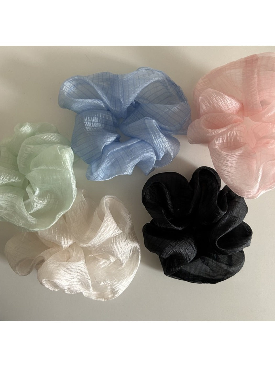 Beige tulle scrunchie styled on a wrist as a bracelet