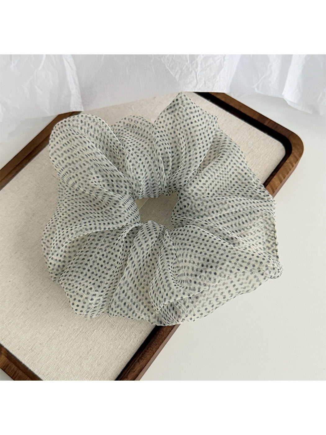 Side view of breathable tulle scrunchie with white polka dots and gathered fabric