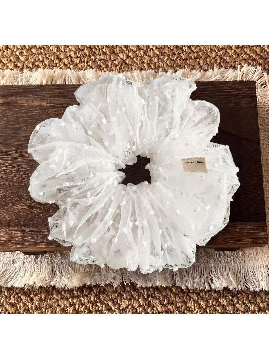 White polka dot tulle scrunchie packaged in a clear plastic bag