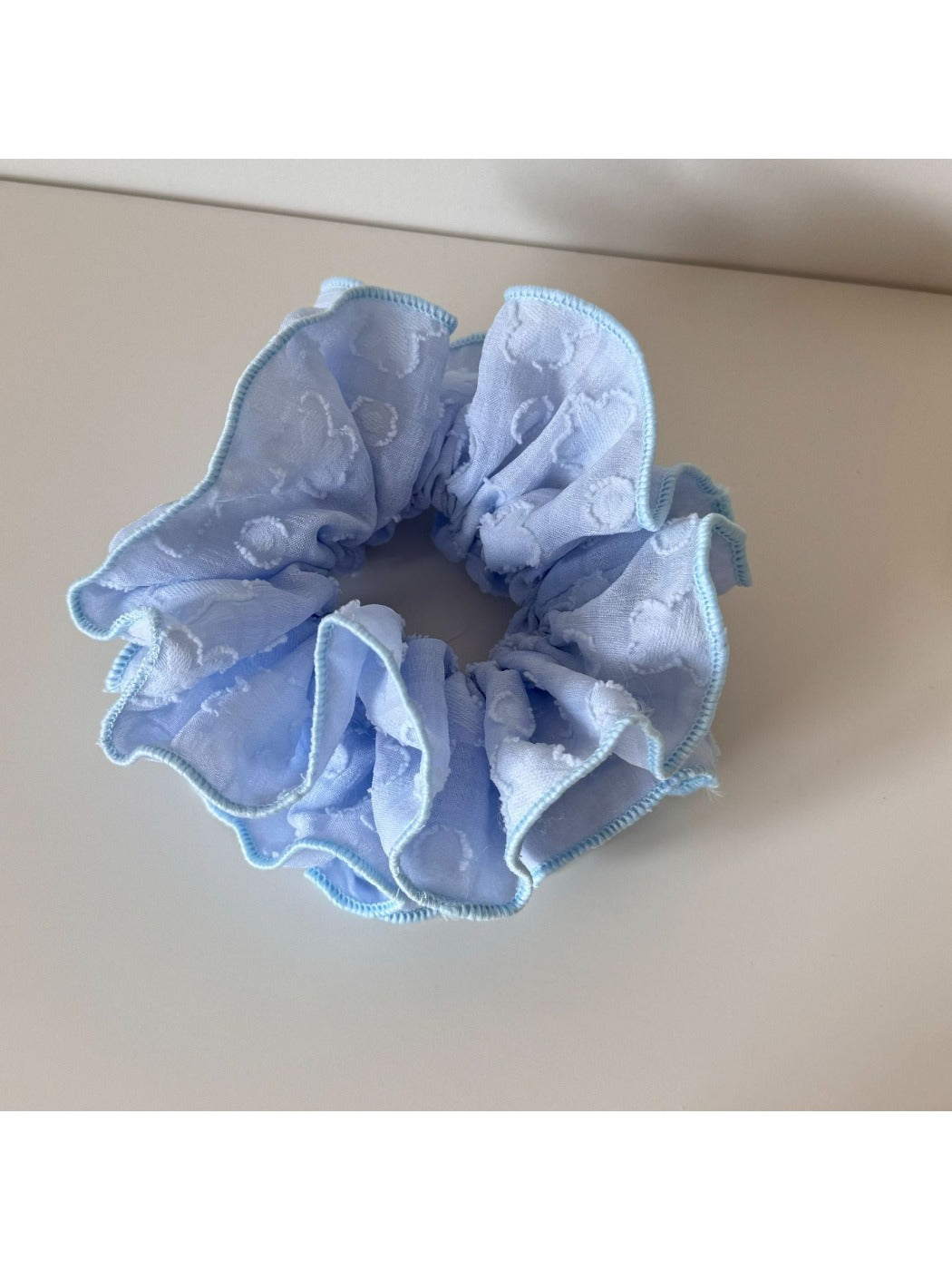 Side view of Gifty Sweet Style floral scrunchie showing gathered fabric and elastic band