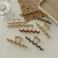 Beau wavy metal claw clip open displaying inner clasp mechanism