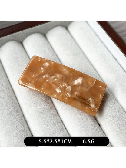 Beau curved bar hair clip displayed on a wooden surface