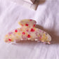 Beau tiny floral acetate claw clip displayed alongside other hair accessories