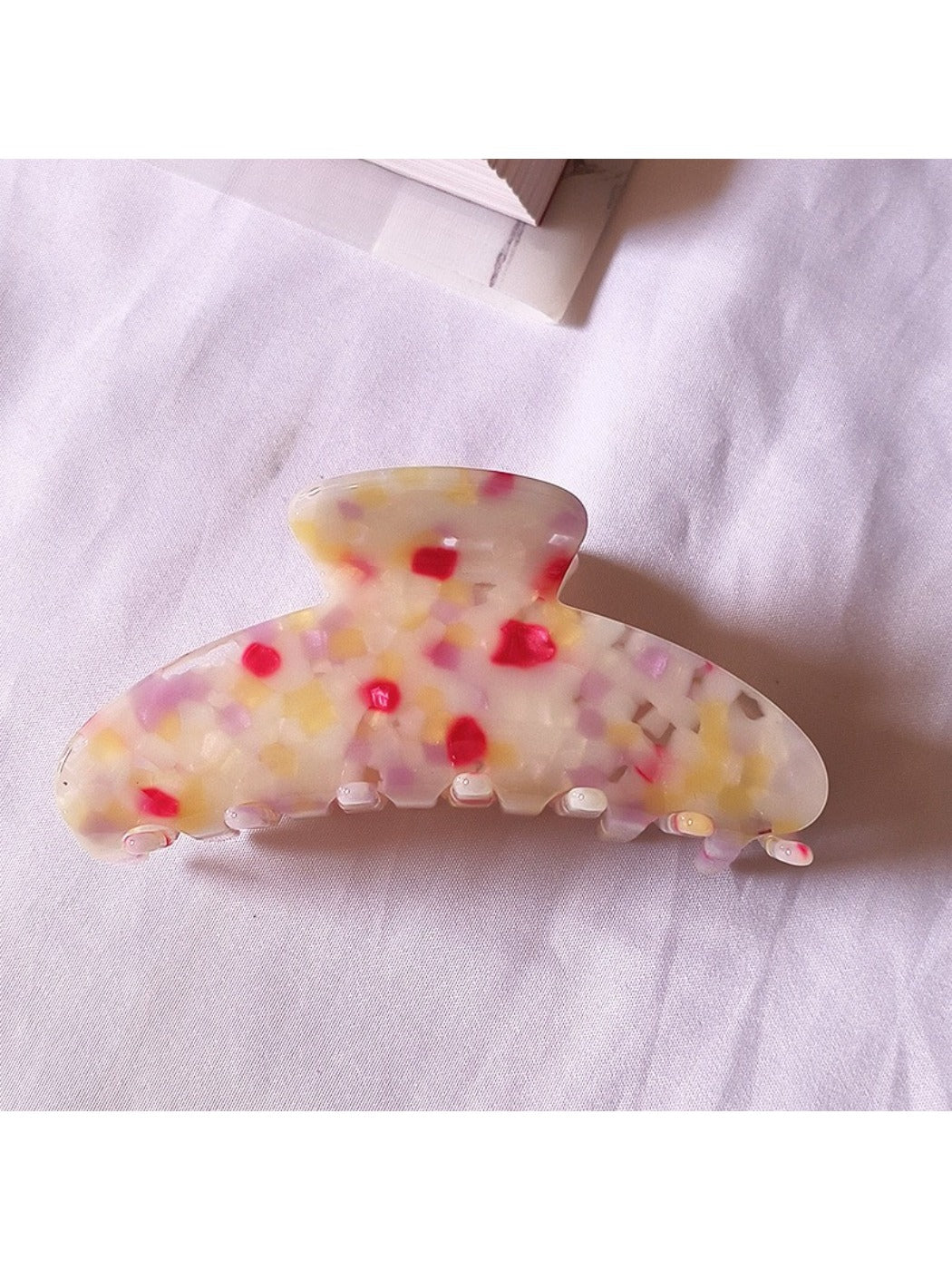 Beau tiny floral acetate claw clip displayed alongside other hair accessories