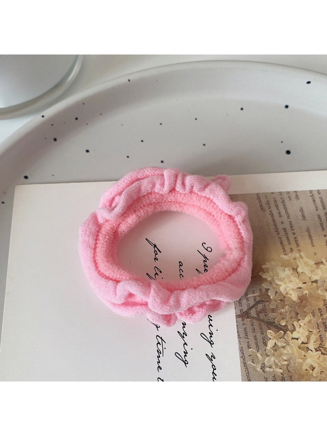 Close-up of a yellow ruffled hair tie wrapped around a wrist