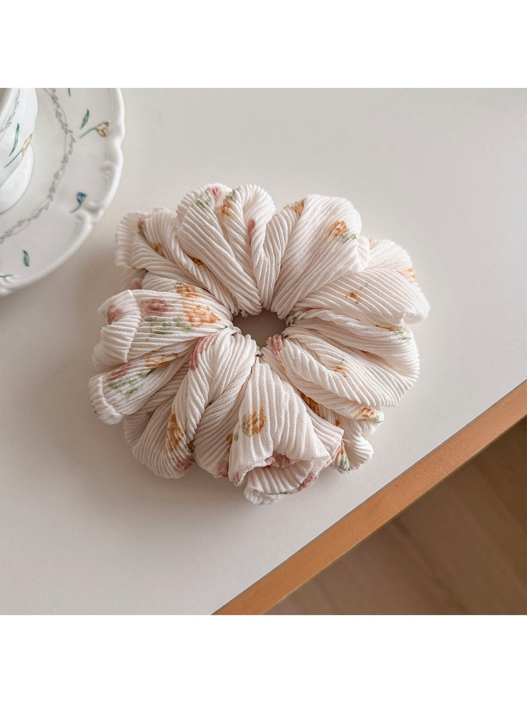 Gifty scrunchie worn in hair, highlighting its ruched and printed fabric