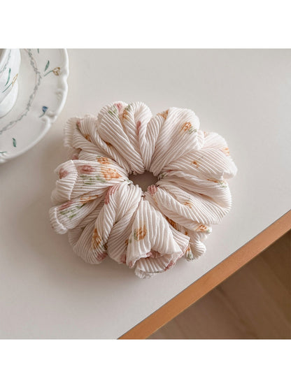 Gifty scrunchie worn in hair, highlighting its ruched and printed fabric